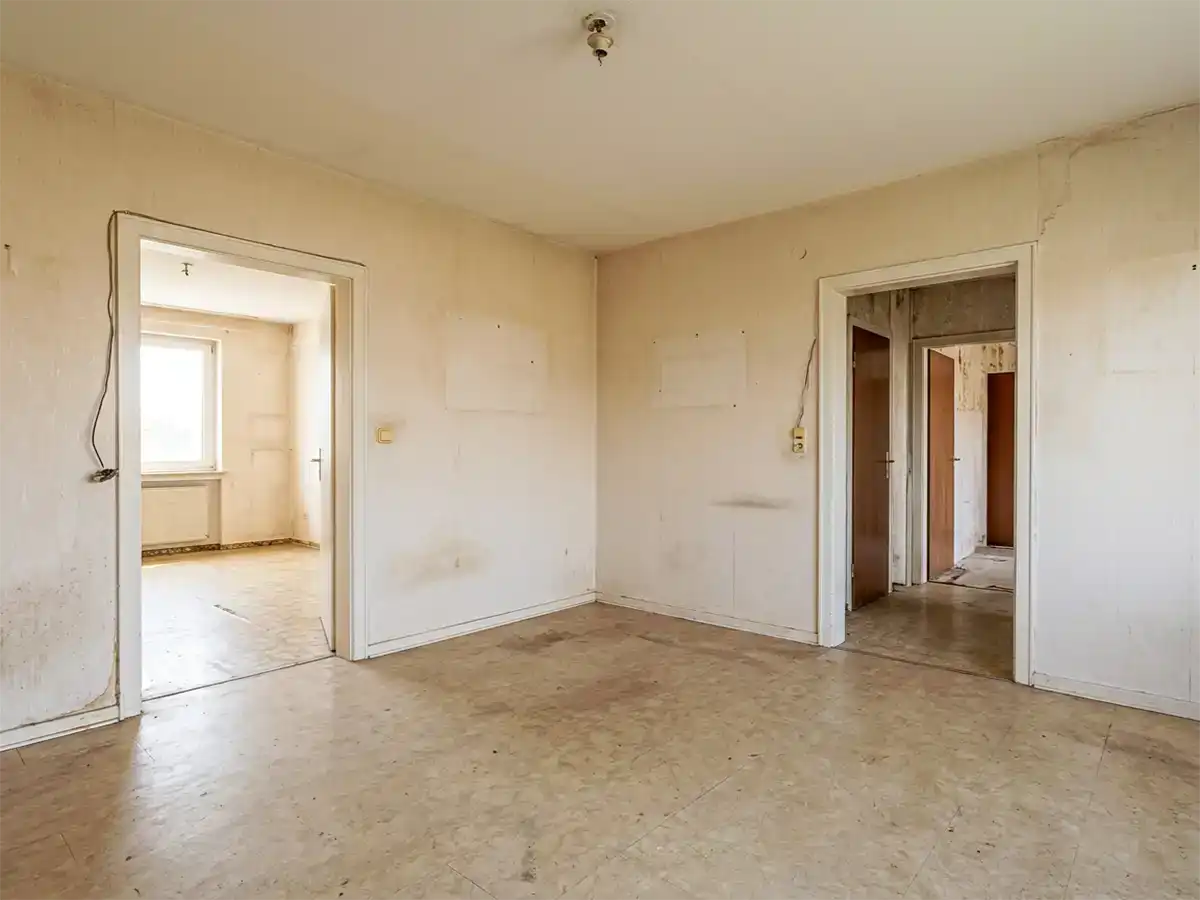 Zimmer mit vergilbter Tapete und altem PVC-Boden vor der Renovierung in Fürth-Hardhöhe